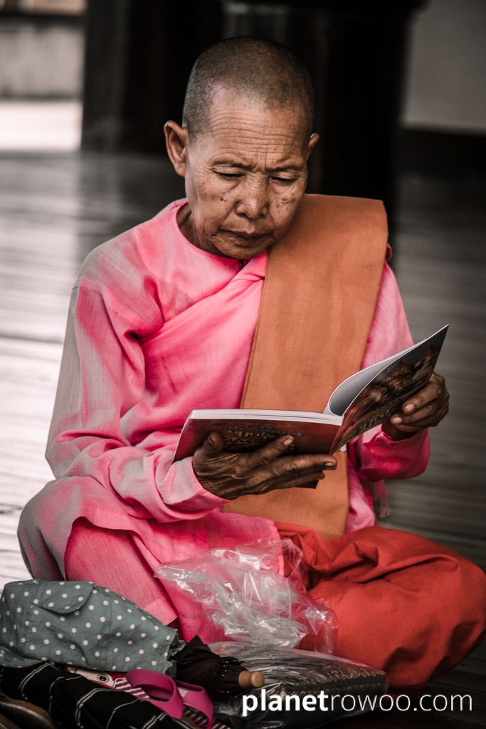 A nun reads from a book at the Shwedagon Pagoda in Yangon, Myanmar, 2017